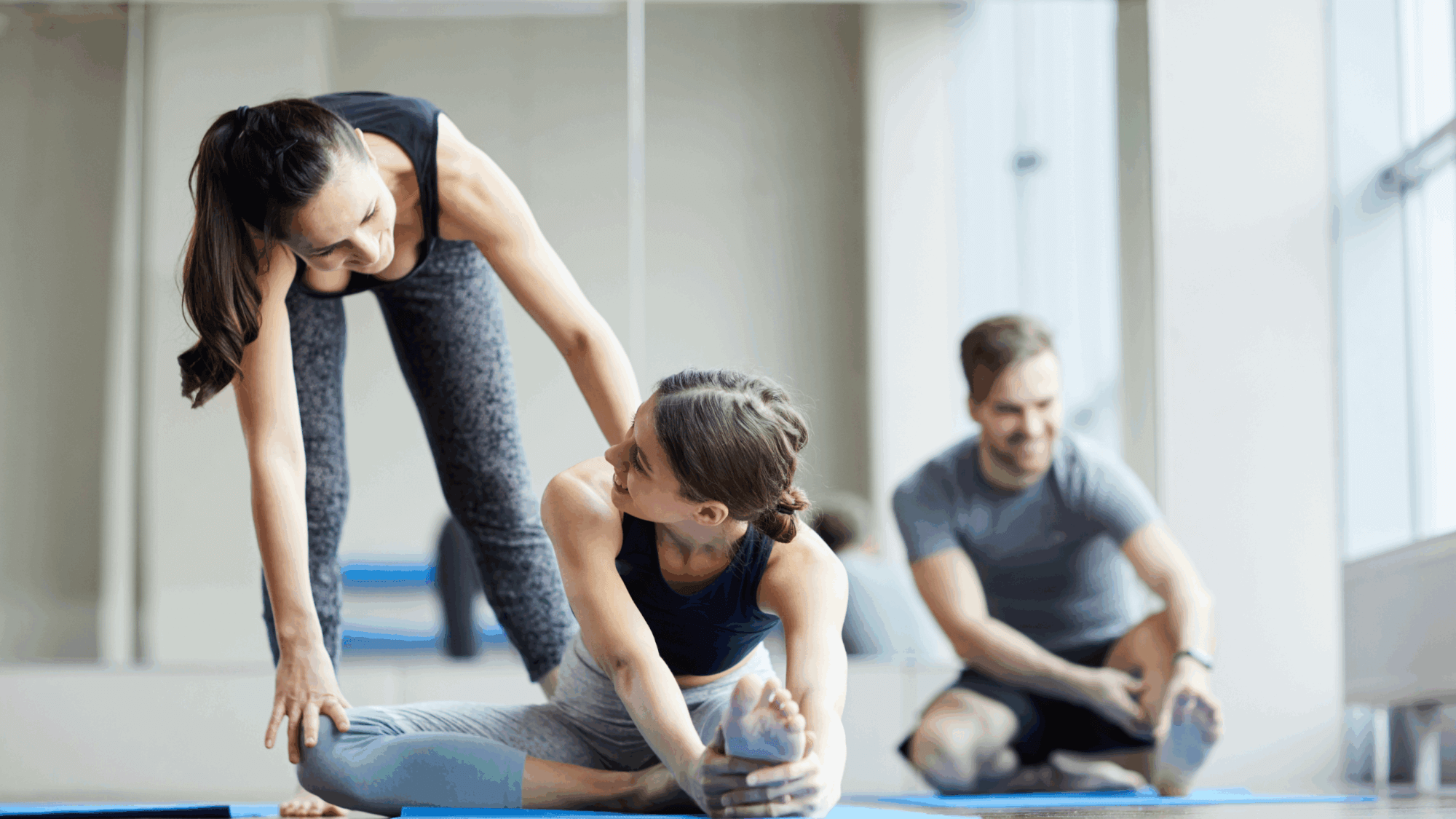 Yogalehrerin unterstützt Yogaschülerin